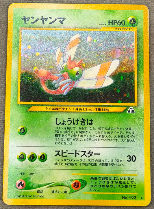 A Japanese Pokémon trading card featuring Yan Yanma, displayed on a gray fabric surface.